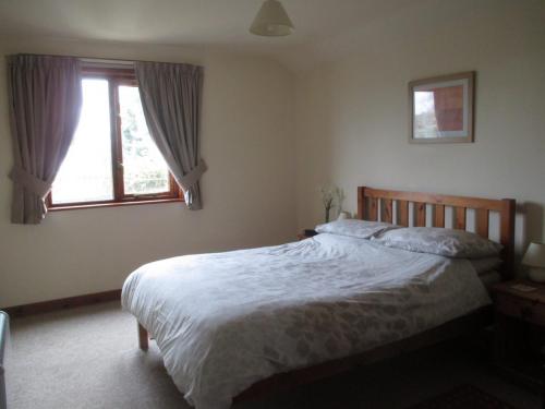 Double room photograph with window in the background. Poppy Cottage, riverside, Brundall, Norfolk.