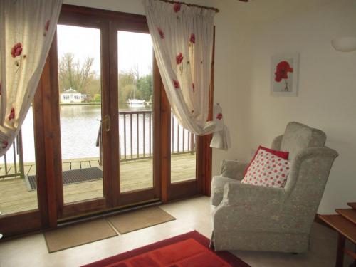 Poppy Cottage in Brundall on the Norfolk Broads. View from the double doors onto the River Yare